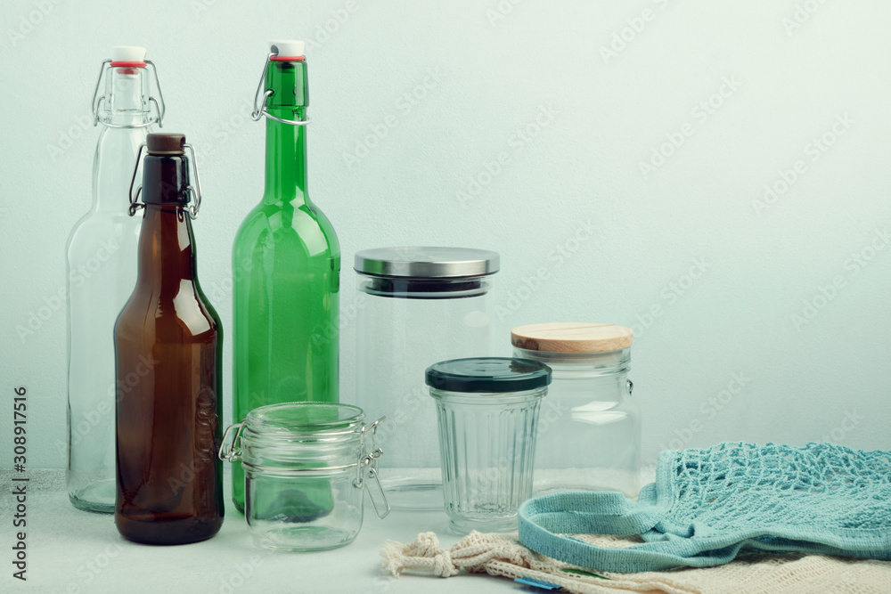 Obraz premium Eco bags, reusable glass bottles and jars on table. Sustainable lifestyle. Zero waste grocery shopping and storage concept