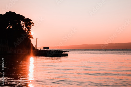 Fototapeta Naklejka Na Ścianę i Meble -  Bright sun early morning sunrise on a rocky beach in split, croatia