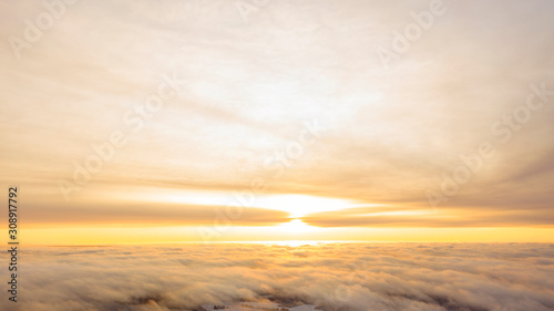 Aerial view White clouds in blue sky. Top view. View from drone. Aerial bird s eye view. Aerial top view cloudscape. Texture of clouds. View from above. Sunrise or sunset over clouds