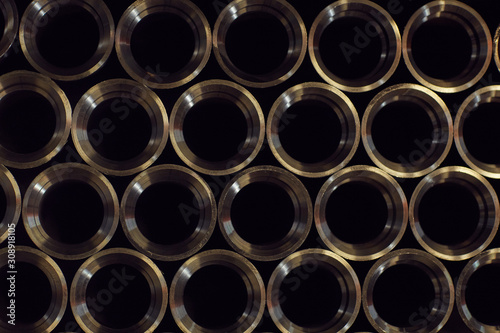 Close-up of large number of new metal pipes in a row in the metal factory