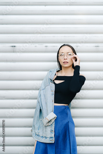 Portrait young woman with glasses. Pretty style woman with long dark hair wearing a denim jacket