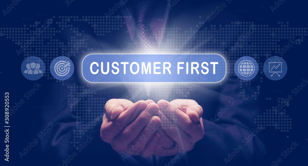 Businessmans cupped hands holding a Customer First business concept on a computerised display.