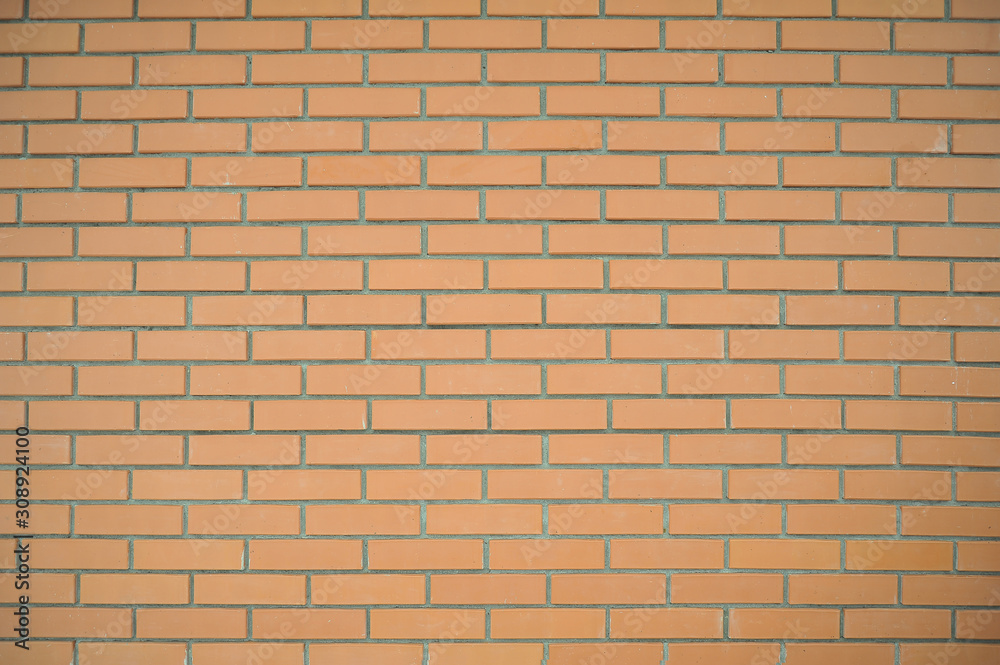 Brick wall of rectangular pale red bricks with gray seams. Background of a brick wall. Brick wall of rectangular pale red bricks with gray seams. Background of a brick wall.