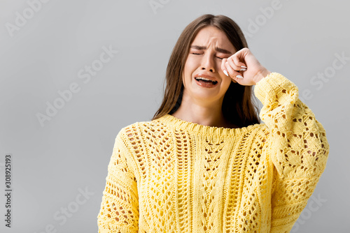 Canvas-taulu offended girl in yellow sweater crying and wiping tears with hand isolated on gr