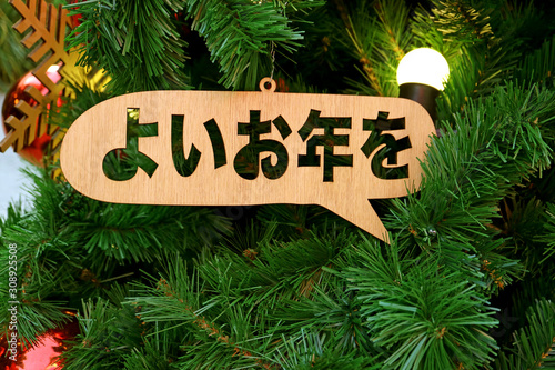 New Year Greeting Ornament in Japanese Word Meaning "HAVE A GOOD YEAR" on the Christmas Tree
