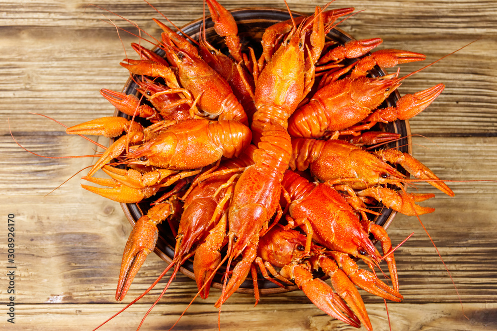 Boiled crayfish in plate on wooden table. Top view Boiled crayfish in plate on wooden table. Top view