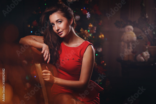Beauty woman on new year background with lights bokeh in red dress