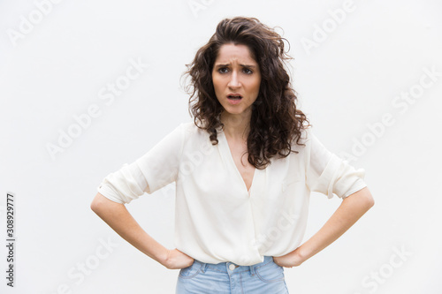 Foto Upset annoyed woman keeping hands on hips and arguing