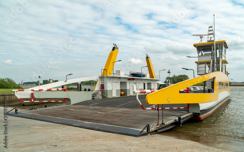 Ferry across the Lek near city of Schoonhoven, the Netherlands. Roll-on roll-off Boat transporting cars and people over the river Lek to the other side.