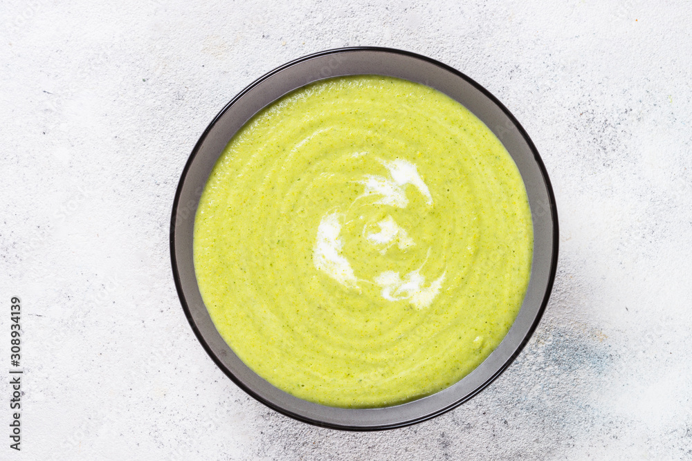 Broccoli cream soup in the bowl on white table. Broccoli cream soup in the bowl on white table.