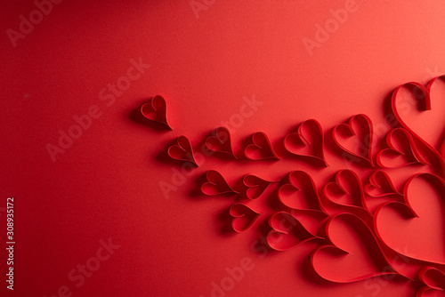 Red paper hearts on red paper background. Love and Valentine's day concept.