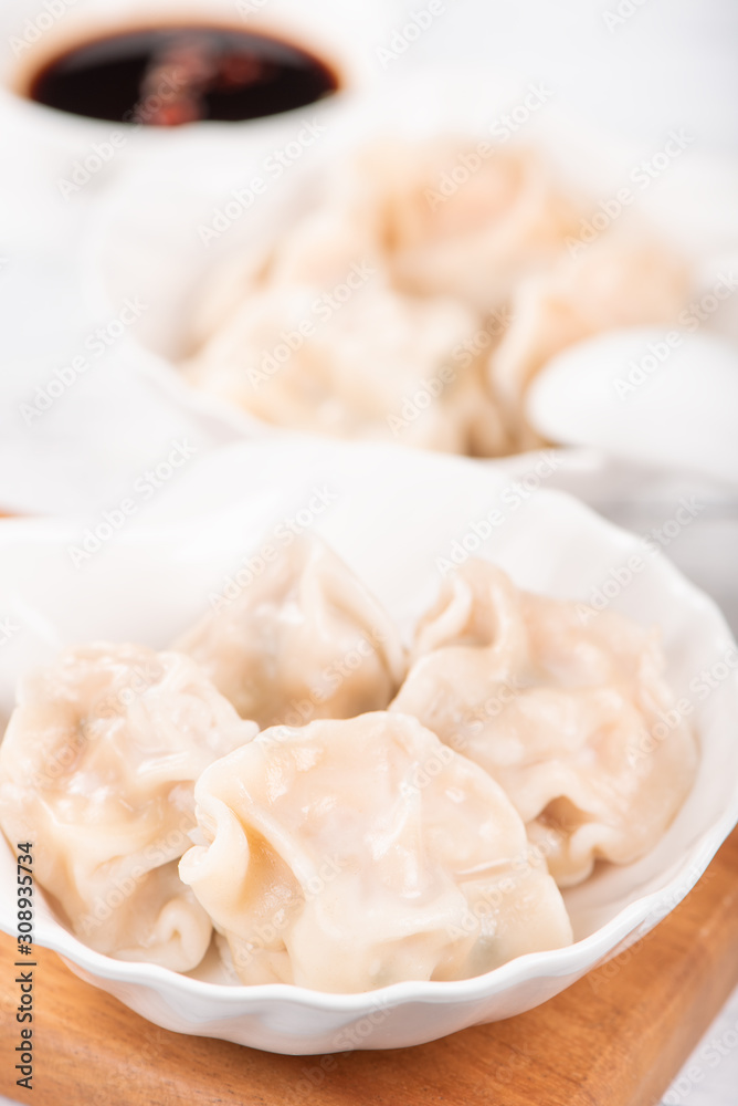 Fresh, delicious boiled pork gyoza dumplings, jiaozi on white background with soy sauce and chopsticks, close up, lifestyle. Homemade design concept.