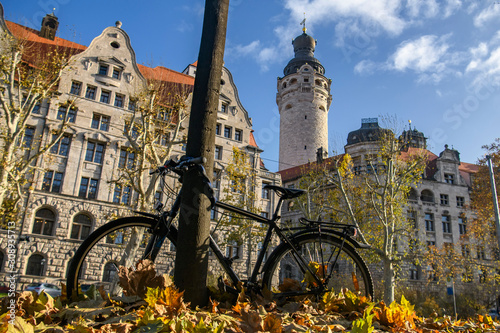 Bicycle parked near a tree around New City Hall Neues Rathaus in historical part of Leipzig, Germany. November 2019