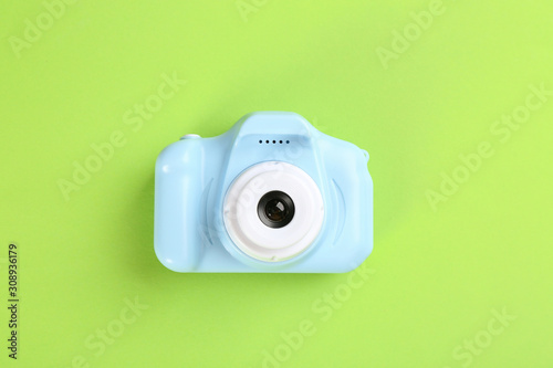 Light blue toy camera on green background, top view