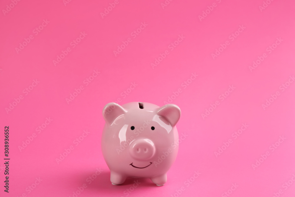 Cute piggy bank on bright pink background