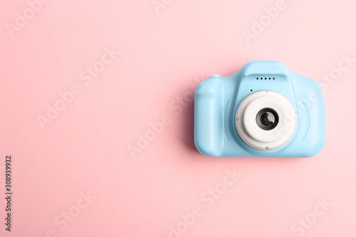 Light blue toy camera on pink background, top view with space for text. Future photographer