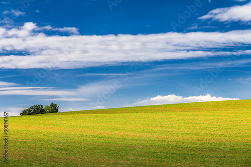 Rural landscape, field with blue sky and clouds in the background at a sunny summer day. Rajec Valley area, Slovakia, Europe.