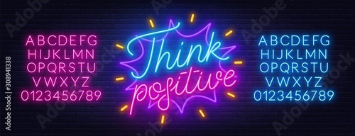 Think positive neon lettering on brick wall background. Neon alphabet on a dark background. Template for design.