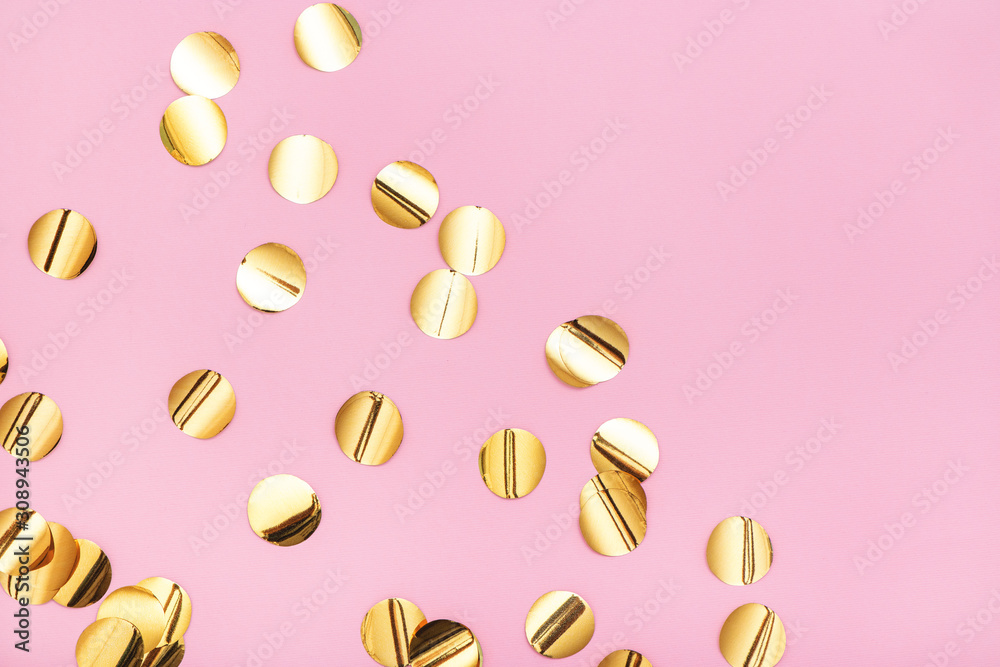 Close up of gold metallic confetti on pastel pink background. Close up of gold metallic confetti on pastel pink background.