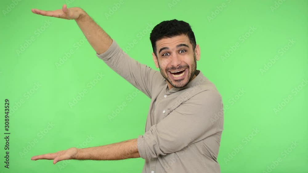 Enthusiastic amazed man in shirt holding copy space between hands, nodding approvingly and looking pleasantly surprised shocked, advertising area for promotional text, mock up. studio shot chroma key Enthusiastic amazed man in shirt holding copy space between hands, nodding approvingly and looking pleasantly surprised shocked, advertising area for promotional text, mock up. studio shot chroma key