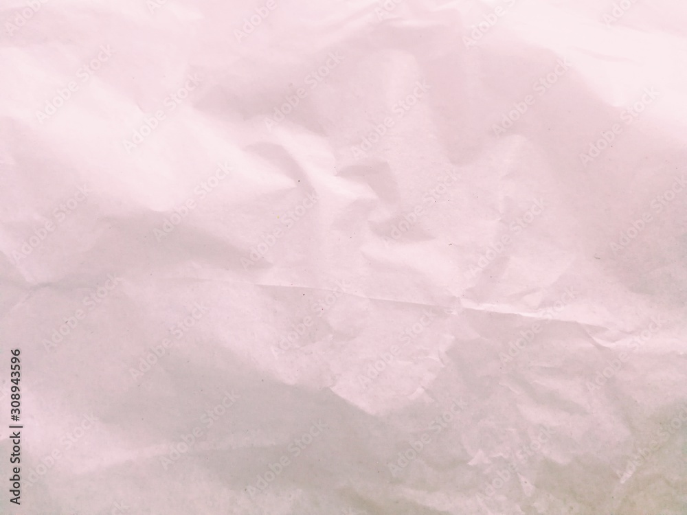 Fototapeta premium Top view of crumpled pale pink paper with a copy space for your work.