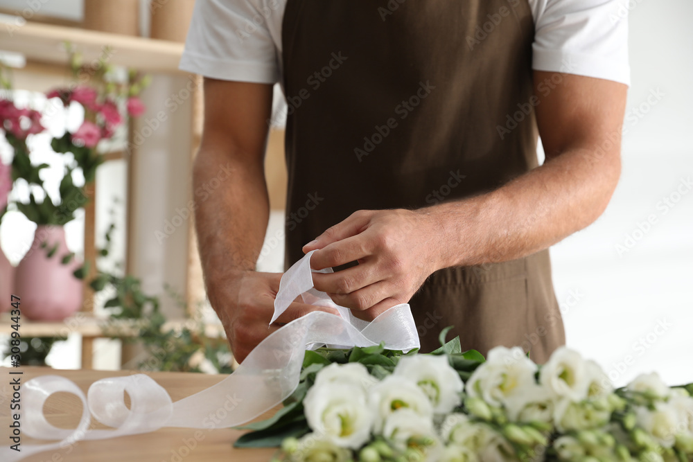 Florist making beautiful bouquet at table in workshop, closeup Florist making beautiful bouquet at table in workshop, closeup