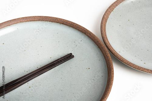 A Pair Of Chopsticks With Stoneware Plate