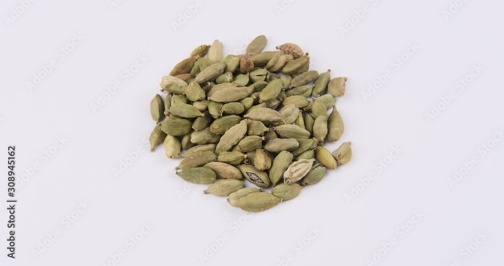 Pile of green cardamom, (dried fruits of Elettaria cardamomum) on white background rotation 360