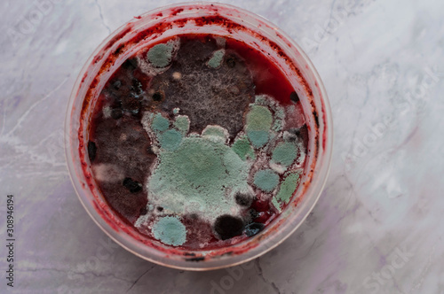 top view of red moldy smoothie in plastik bowl on marble background
