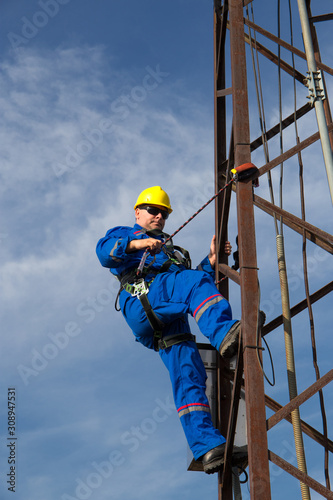 Worker prepares safety belt to work on lamppost
