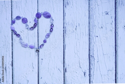 heart of purple beads on a background of light boards