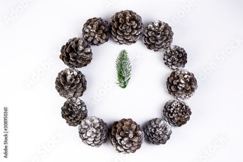 Christmas time concept. Mock Christmas clock and watch made of pine cone and fir branches. Holiday and New Year decoration