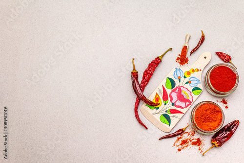 Fototapeta Naklejka Na Ścianę i Meble -  Magyar (Hungarian) red sweet and hot paprika powder. Traditional pattern on a cutting board, different varieties of dry pepper. Stone concrete background