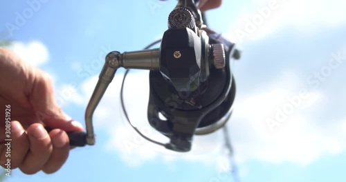 fisherman with fish rod trying to catch carp. Gear coil movement.