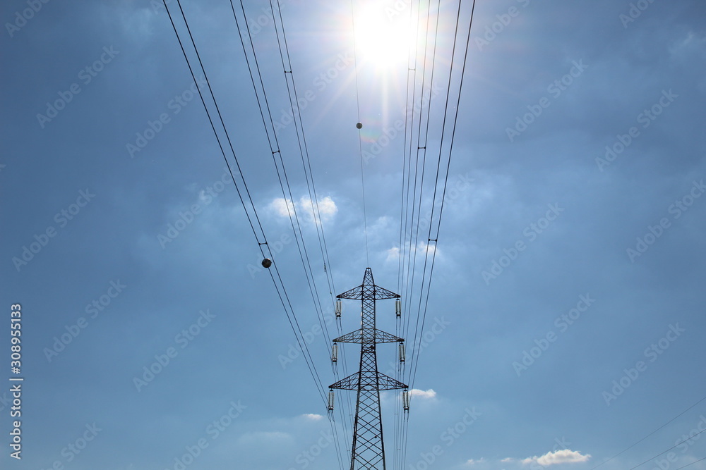 Electricity Pylon and Power Lines on partly Sunny and Cloudy Background Electricity Pylon and Power Lines on partly Sunny and Cloudy Background