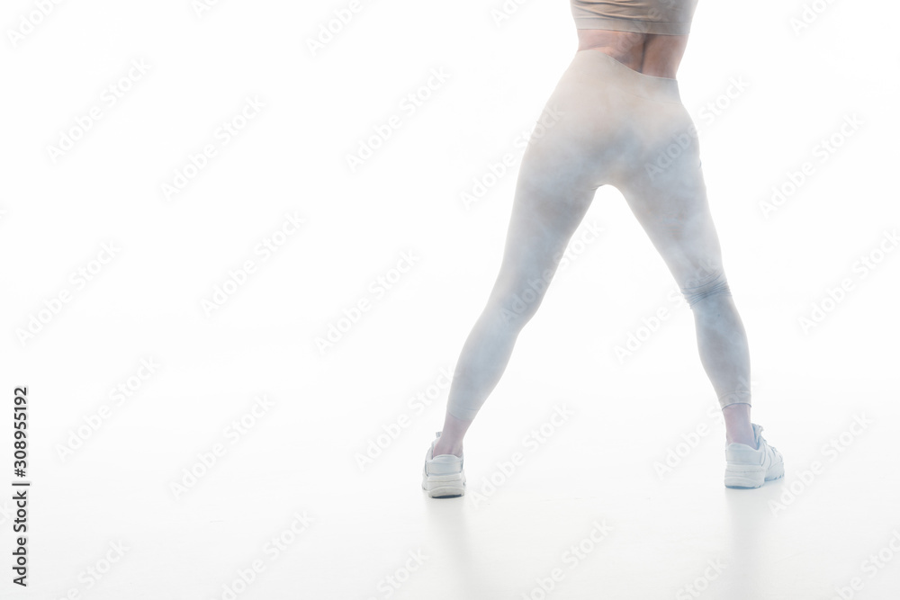 back view of blonde girl in beige leggings twerking in smoke isolated on  white Stock Photo | Adobe Stock