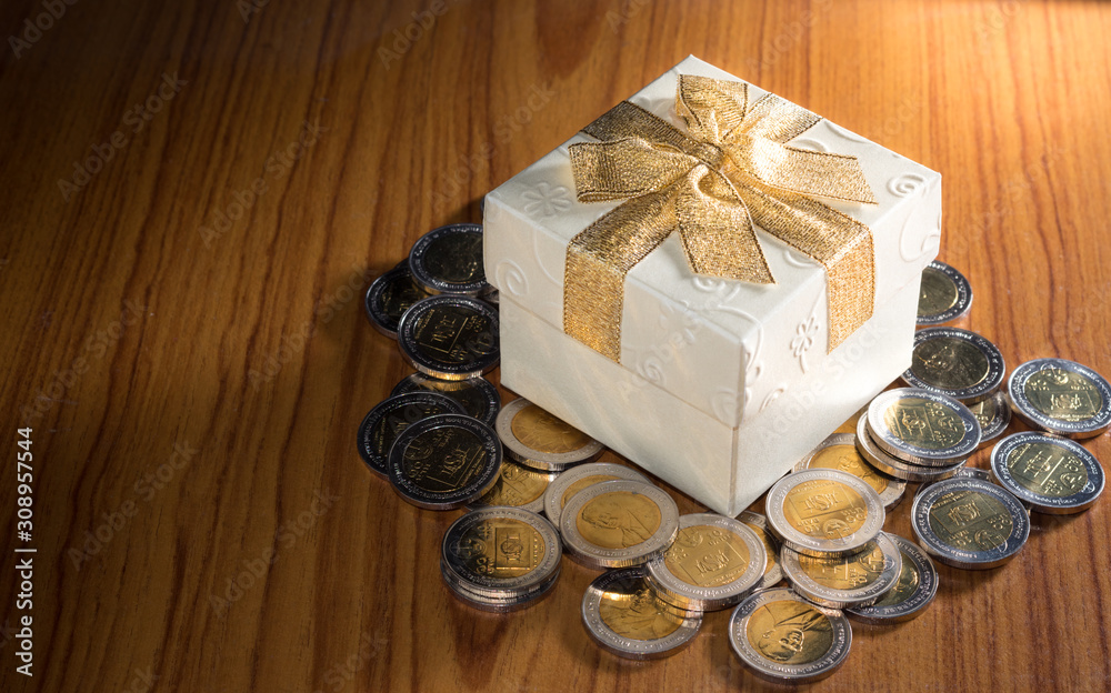 Gift box with money coins on table. Gift box with money coins on table.