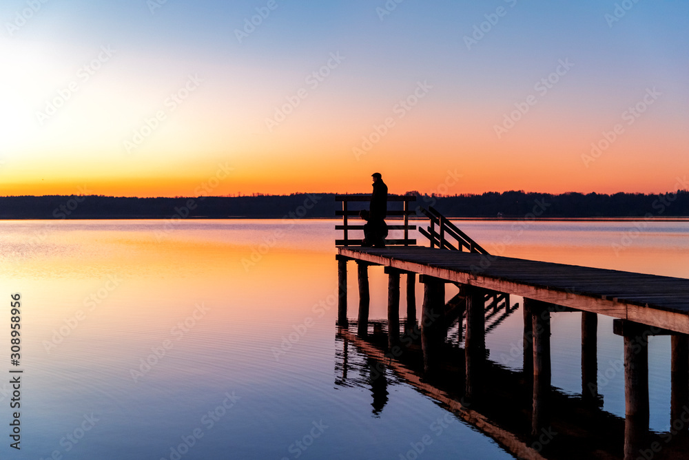 Person auf einem Steg am Starnberger See