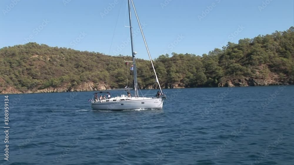 Team of people on sailing yacht with white sails in yachting regatta. Sea, mountains, summer and white yachts.Yachting as an active lifestyle. concept of water transport, travel and recreation. Team of people on sailing yacht with white sails in yachting regatta. Sea, mountains, summer and white yachts.Yachting as an active lifestyle. concept of water transport, travel and recreation.