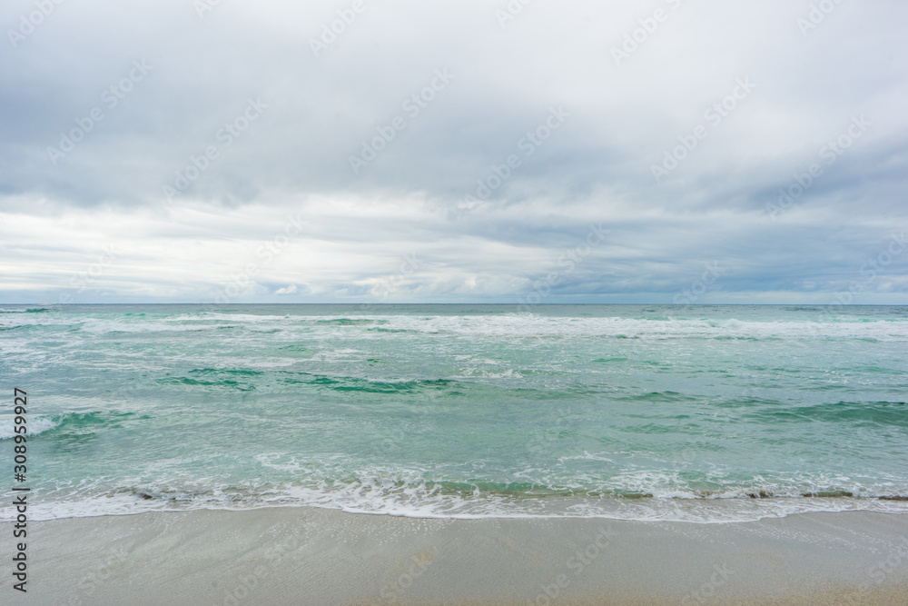 View towards the ocean at Unstad beach, Vestvågøy, Lofoten Islands, Norway. Soft colors, sand, wawes and clouds. View towards the ocean at Unstad beach, Vestvågøy, Lofoten Islands, Norway. Soft colors, sand, wawes and clouds.