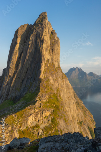 Cliff wall bathed in evening sun. The mountain top Segla shaped as a sail, Senja, Norway.