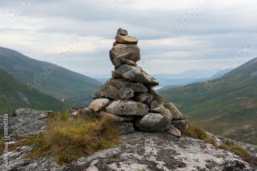 Cairn in front of mountain landscape. Seen from high perspective. Grey and clouded weather that gives a calm feeling. Senja, Norway. © Ida Haugaard Olsen