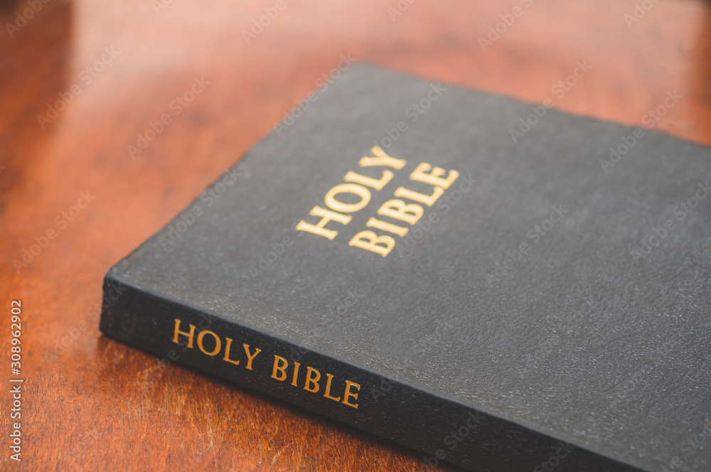 Bible on a wooden background. Concept for faith, spirituality and religion Bible on a wooden background. Concept for faith, spirituality and religion