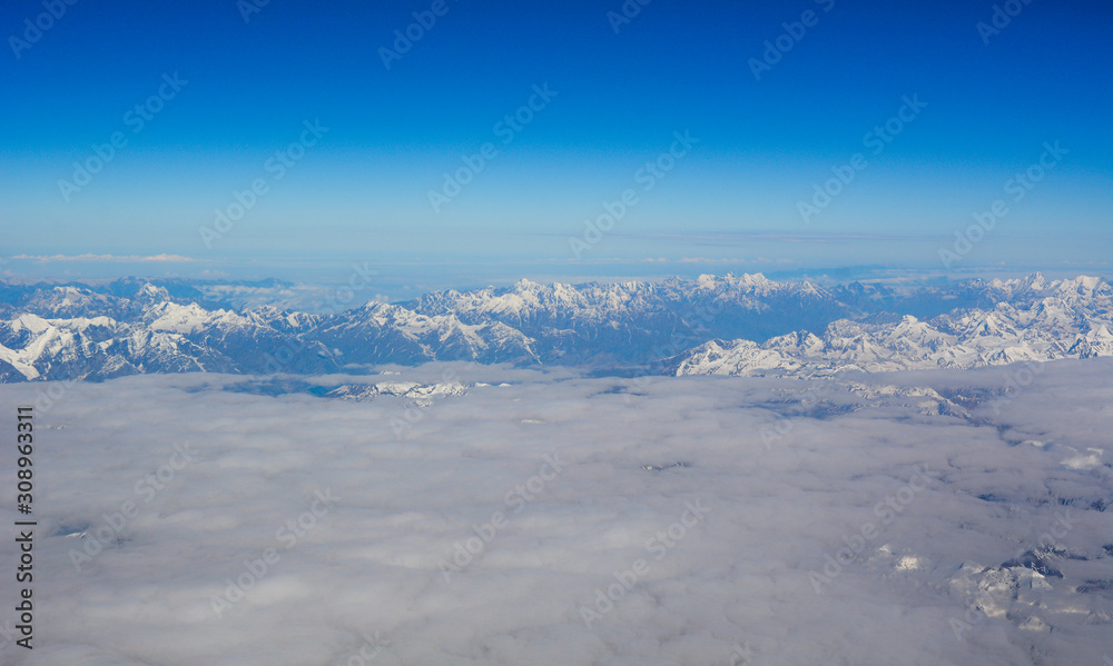 Fototapeta premium Aerial view above snow mountain peaks