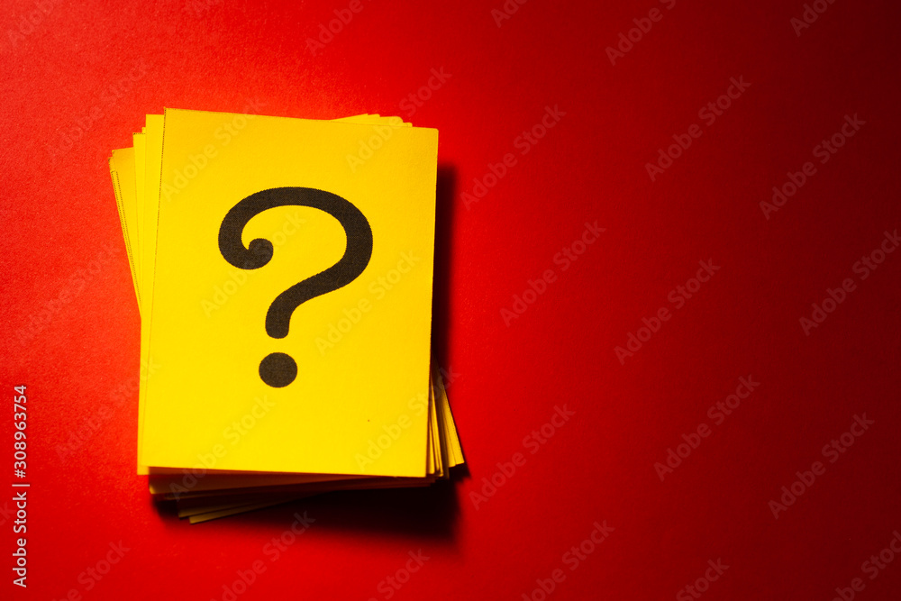 Stacked yellow cards with printed question mark Stacked yellow cards with printed question mark