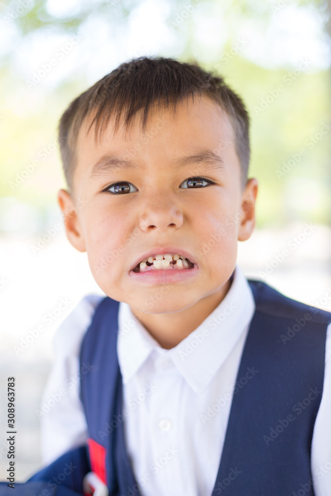 Portrait of child in school uniform looking at camera and showing teeth. Portrait of child in school uniform looking at camera and showing teeth.