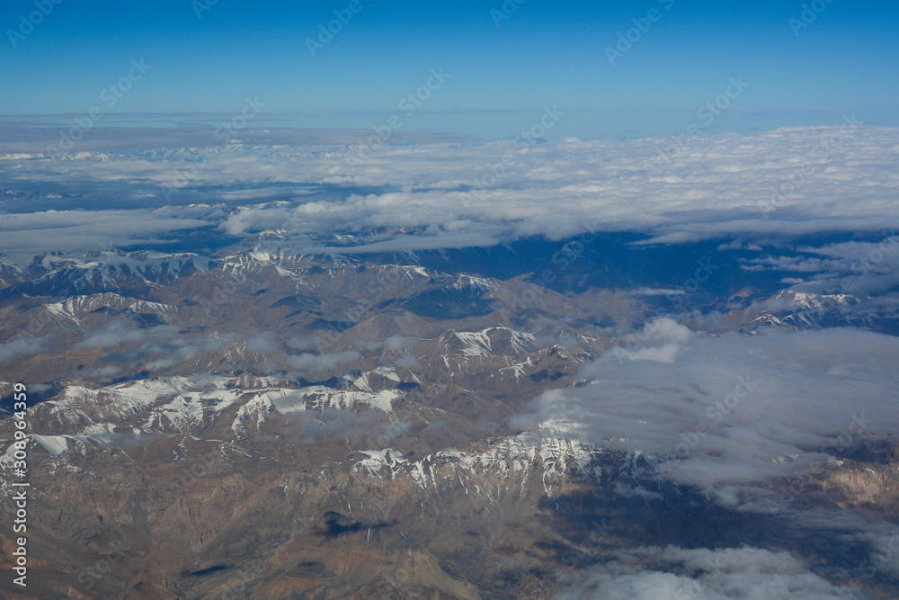 Aerial view above snow mountain peaks