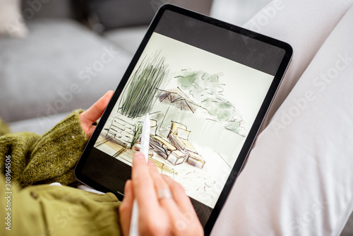 Photo Artist or designer making landscape design, drawing on a digital tablet with pencil, close-up on a screen
