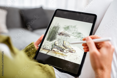 Fotobehang Artist or designer making landscape design, drawing on a digital tablet with pencil, close-up on a screen