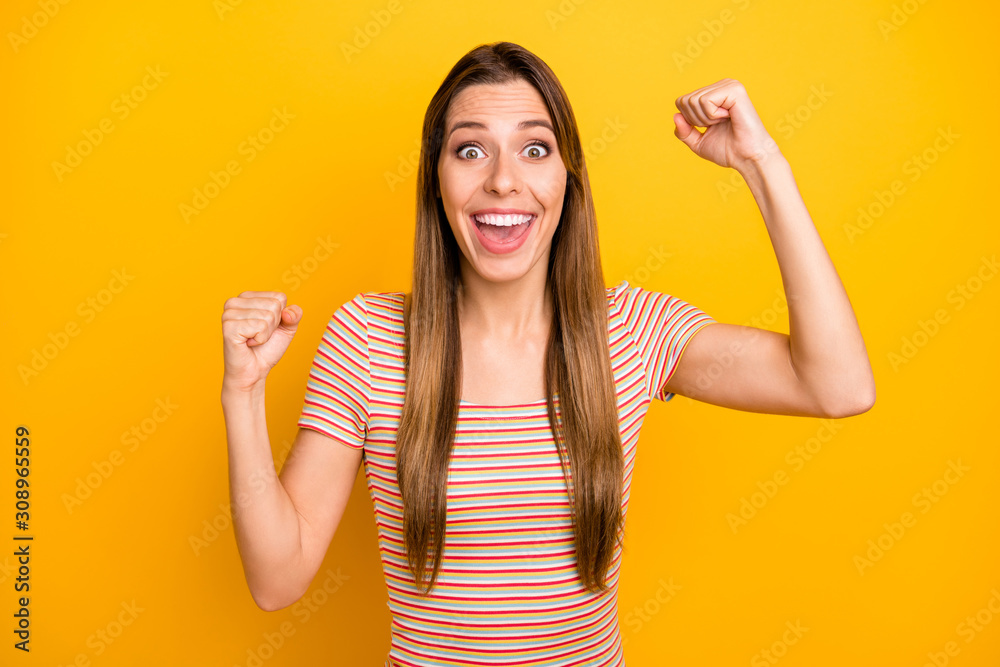 Yeah. Photo of attractive lady yelling loudly unexpected money lottery winning raising hands fists crazy person wear casual striped t-shirt isolated yellow color background Yeah. Photo of attractive lady yelling loudly unexpected money lottery winning raising hands fists crazy person wear casual striped t-shirt isolated yellow color background